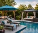 Luxury backyard pool with chaise lounges, a cantilever umbrella, pergola, gazebo, and comfortable outdoor seating.
