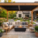 Elegant backyard patio featuring a pergola, coordinated outdoor seating, decorative planters, lanterns, and a modern fire pit in a timeless outdoor living space.